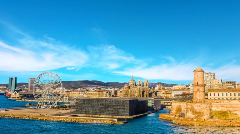 Cidade de Marselha vista do mar, com fortalezas e a grande roda-gigante na chegada ao porto