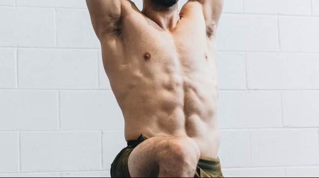 Fit Male Athlete about to have a massage and doing mobility test