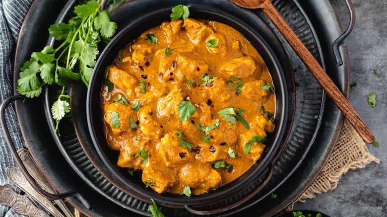 thm recipe coconut curry in a black bowl next a wooden spoon