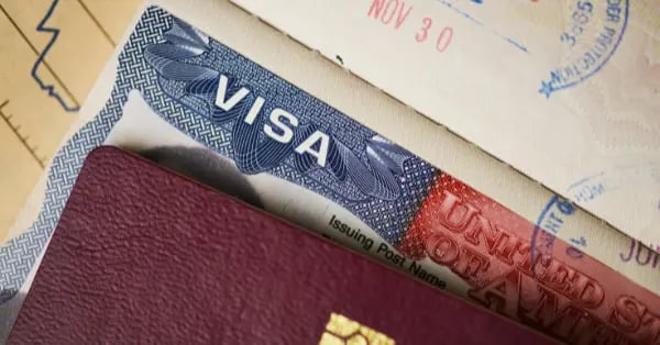 Close-up of a United States travel visa stamp inside a passport with official entry dates.