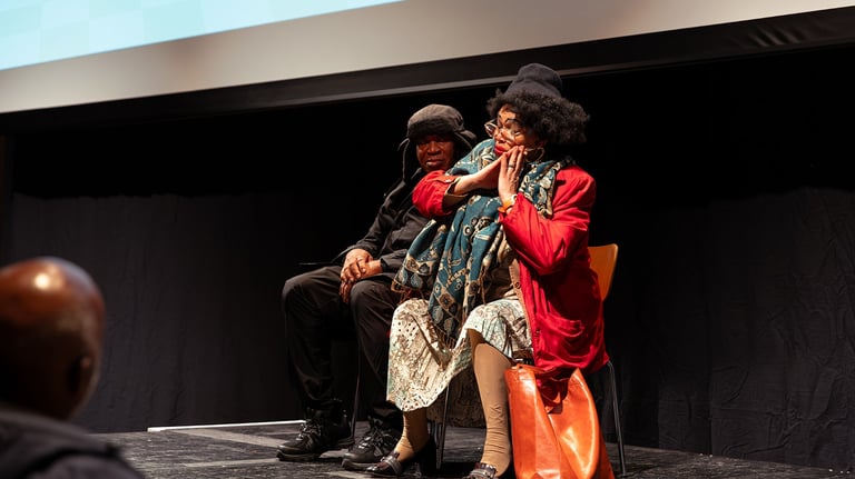 a man and woman sitting on a stage