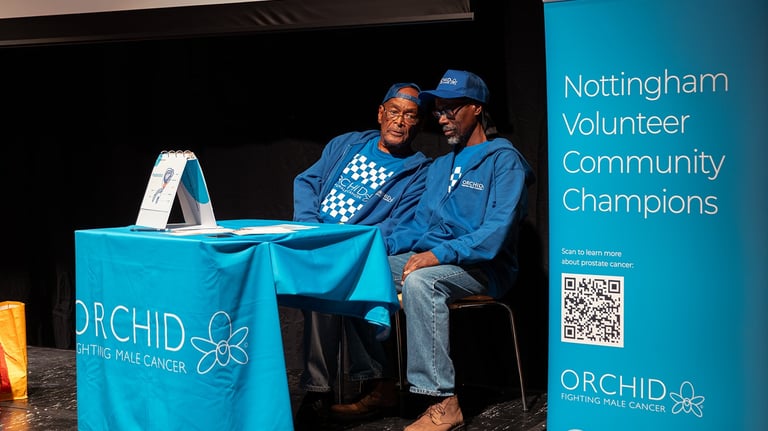 two men sitting at a table with a laptop