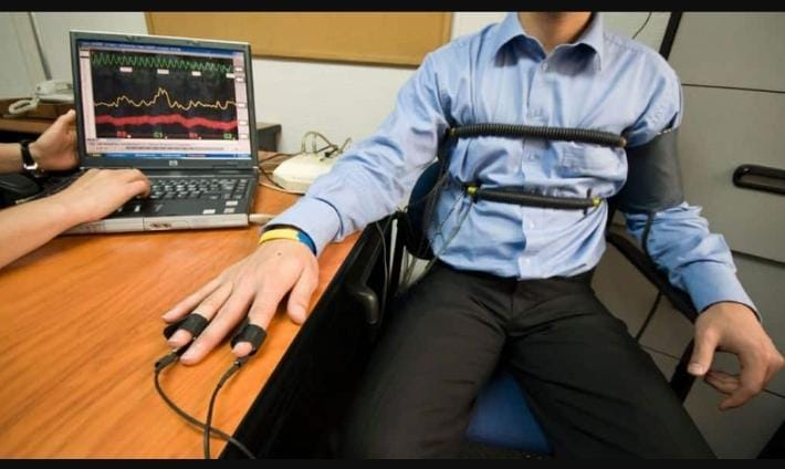 a man in a wheelchair with a computer monitor and a laptop