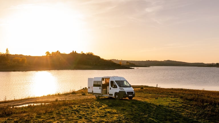 a van parked on a grassy field near a body of water
