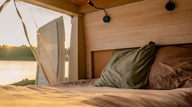 a bed with a view of a lake and a boat
