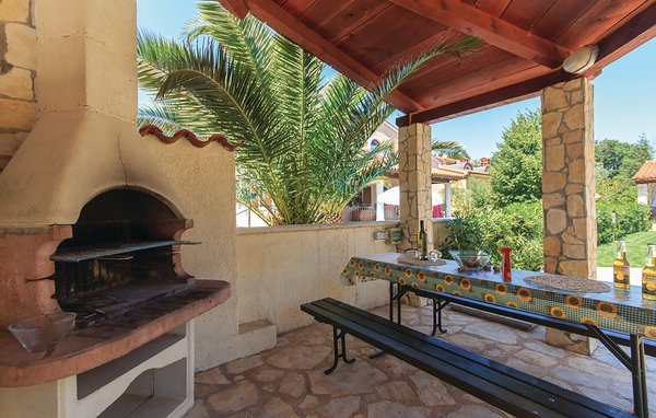 Shared barbecue and outdoor dining area by the pool in Volme