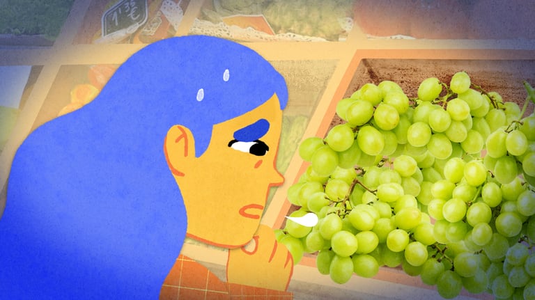a blue-haired girl looks to some grapes with a concerned face