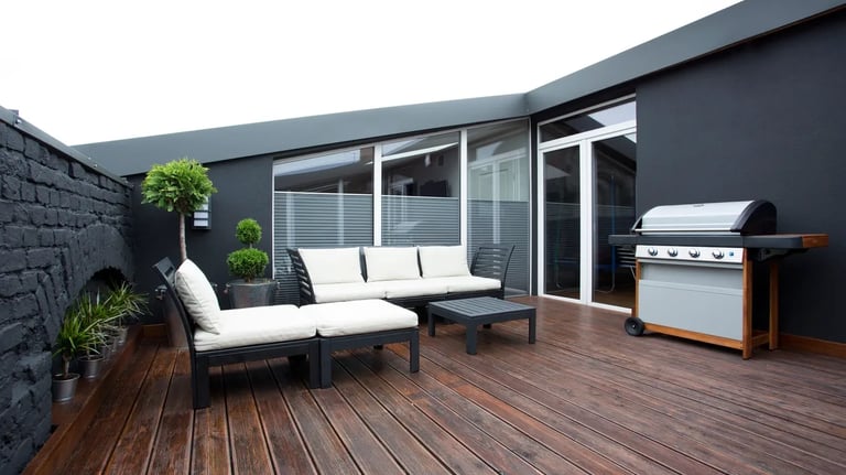 a patio with a couch and a grill