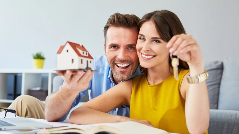 a man and woman holding keys to a house