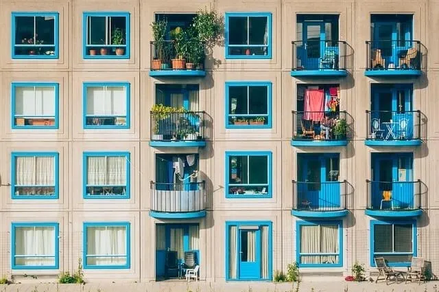 a building with blue windows and a balcony with blue windows