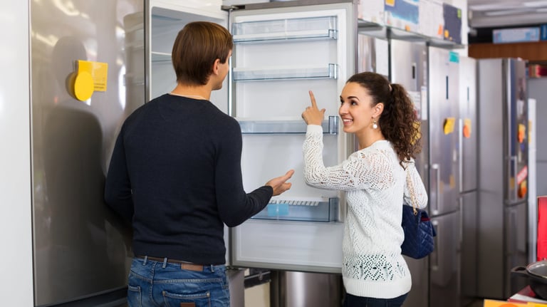 sales person showing a customer new fridge in an appliance store