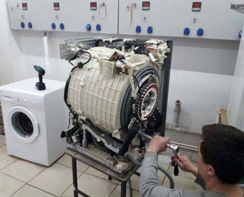 washer outer cover is removed and a technician repairing the shocks of the washer