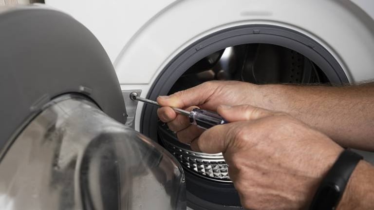 person tightening the door screw of a washer
