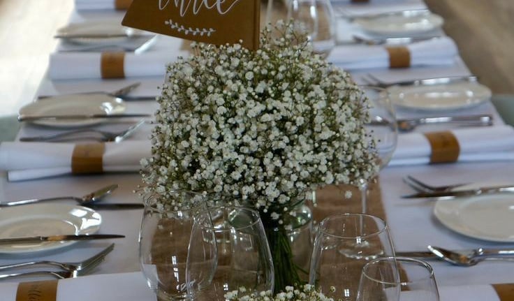 Recepcion de mesas, decoradas, con manteles, platos, flores 