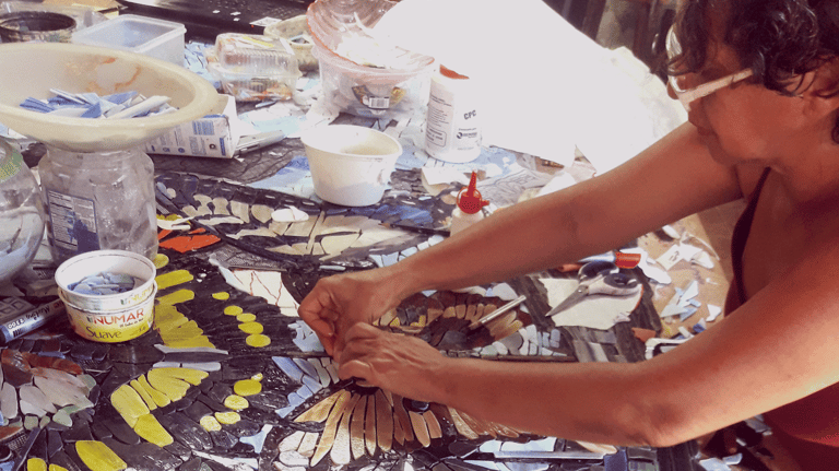 a woman is designing a mosaic tile