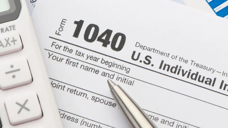 Partial view of a calculator, a pen and of a U.S. Form 1040.