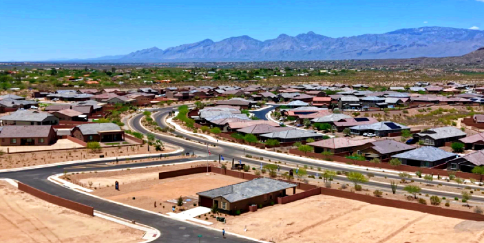 a city street with a lot of houses and mountains in the background