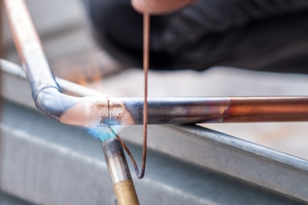 Gasfíter realizando soldadura en tubería de cobre