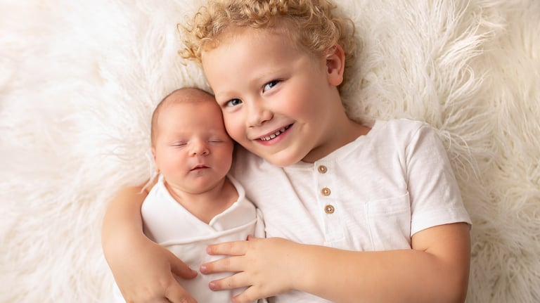 a baby and his brother are posing for a photo