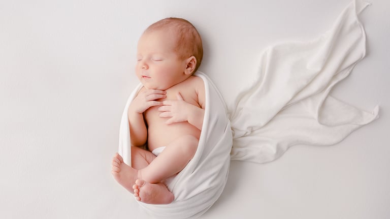 a baby is sleeping in a blanket wrapped in a blanket