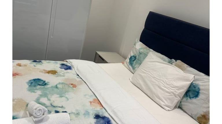 a well kept bed with a blanket and towels on it