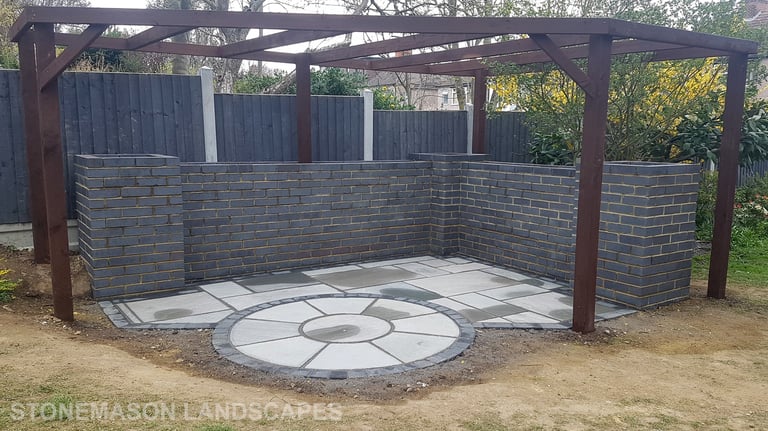 Blue Perforated Brick Wall Planter With Grey Sandstone Circle & Patio Paving & Wooden Pergola