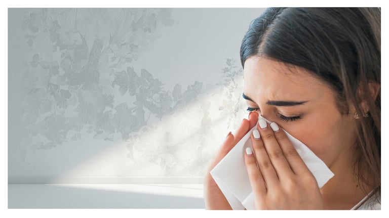 A woman sneezing into a white tissue suffering from seasonal allergies, cold, or flu symptoms.