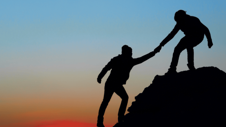 two people holding hands on a mountain top