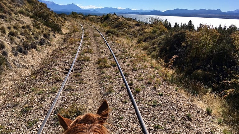 An abandoned railroad track in a mountainous landscape.