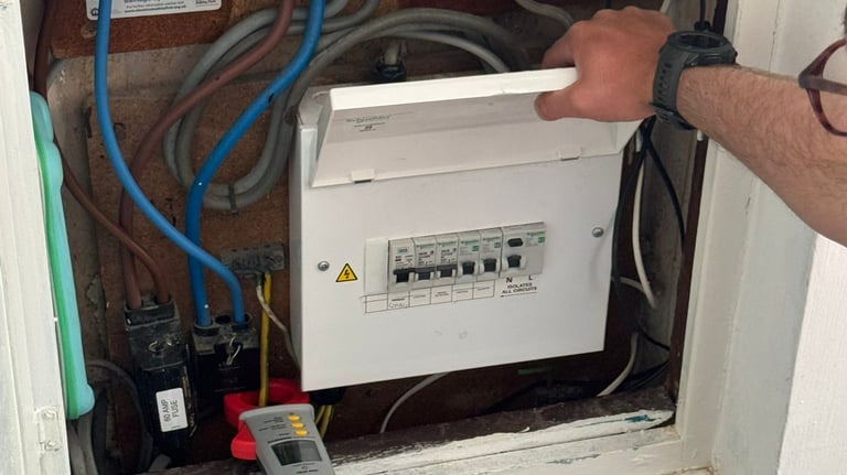 Electrician inspecting fuse board in Norwich