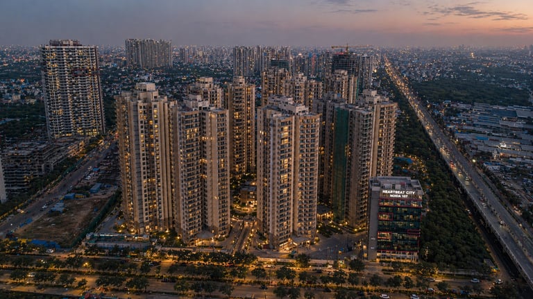 Luxury high-rise residential apartments at sunset with a landscaped park and central water feature.