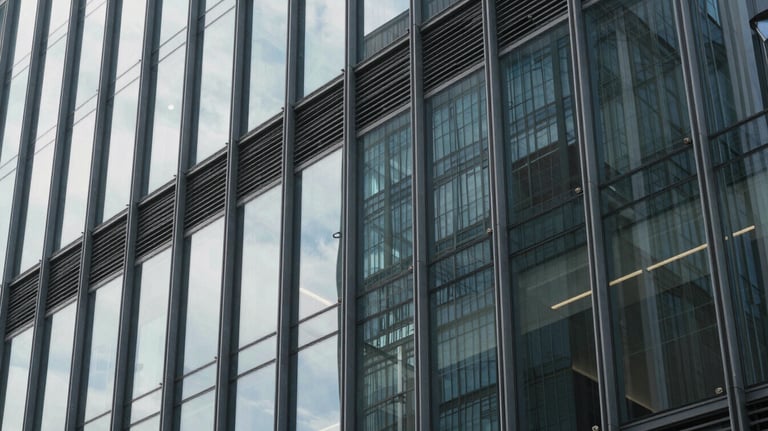 A photograph focusing on the modern architectural detail of a glass building façade, capturing the professional and trustworthy mood of a financial center.
