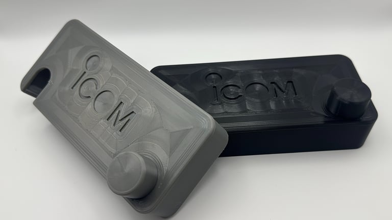 Custom 3D printed radio cases in grey and black featuring the ICOM brand logo.