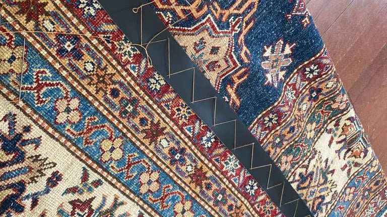 Pattern rug with leather backing and carpet strapping reinforcement.