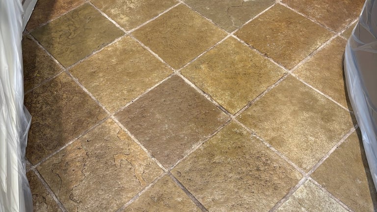 Dirty slate tile floor in kitchen before professional cleaning