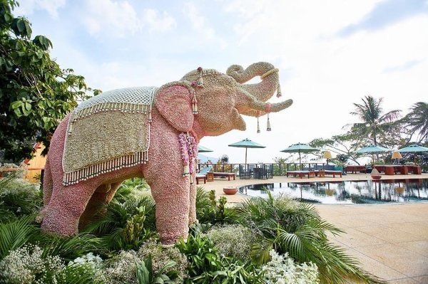 a pink elephant statue in a garden