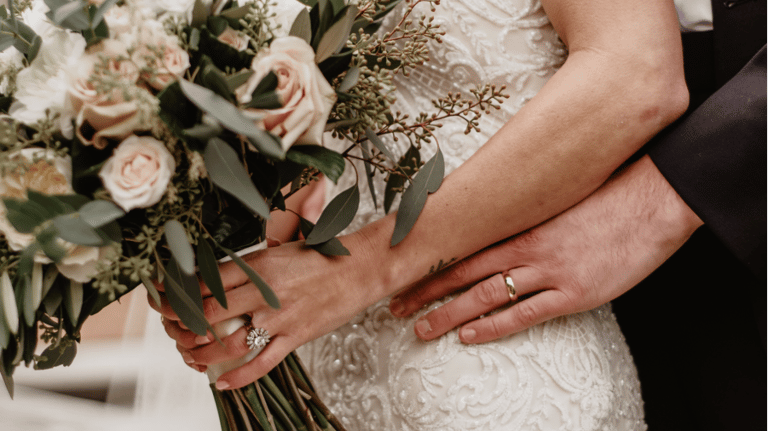 a bride and groom holding a bouquet of flowers