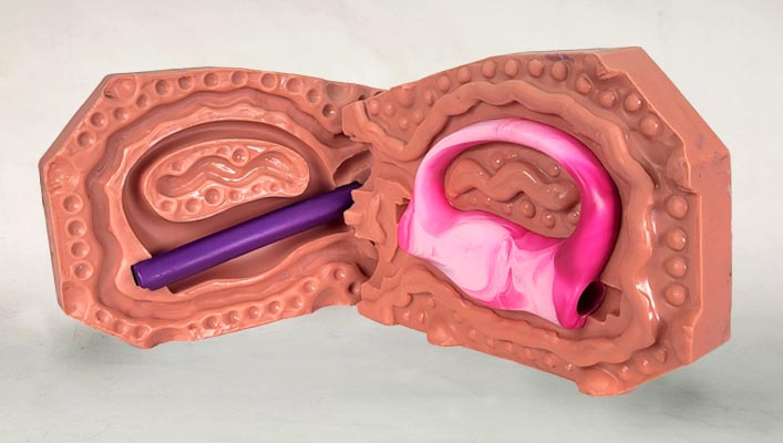 Picture of an open 2 piece silicone mold. The mold has a pink marbled grip in the mold cavity. 