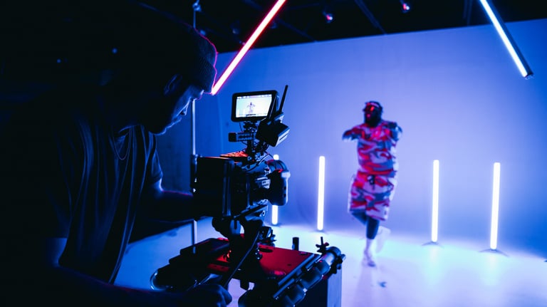 a man in a red shirt is standing in front of a camera - Swrill