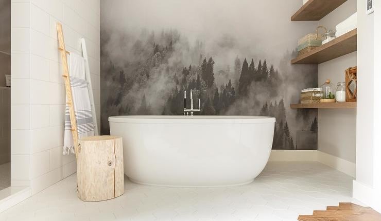 Modern bathroom with a white soaking tub and a misty forest wall mural.