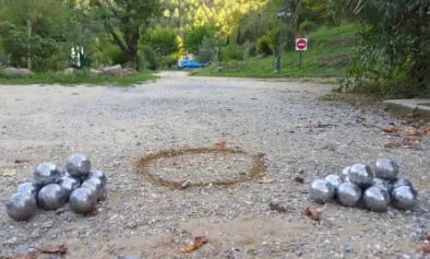 deux amas de boules de pétanques sur un terrain de pétanque