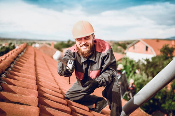 roofing worker smiling for the camera on an orange roof