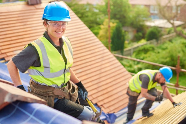happy roofing worker smiling for the camera while the other installs