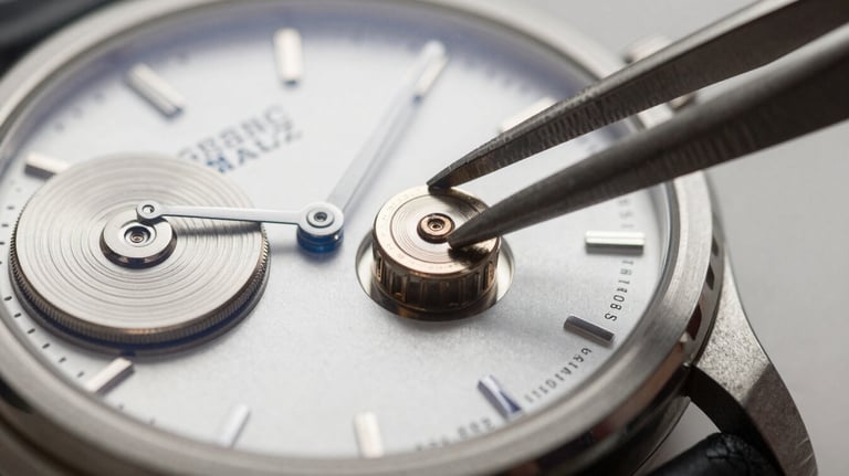 A macro photograph focusing on a small silver watch battery being placed into a high-end Swiss watch movement with precision tweezers, clean lighting.
