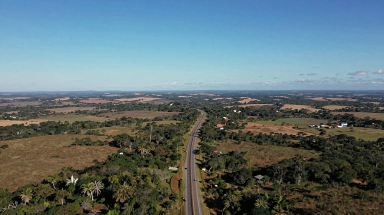 An aerial photograph showing a highway winding through a South American / Brazilian landscape under a clear blue sky. The image represents the vast reach and global signal of the tracking service.