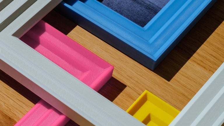     Customizable 3D printed colorful photo frames placed on a desk