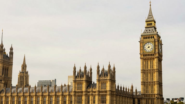 A crisp, professional architectural shot of Big Ben and the Houses of Parliament in London, featuring a soft off-white sky and elegant gold lighting.