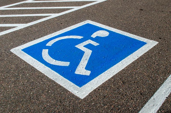 Blue and white handicap parking symbol painted on asphalt in a reserved accessible space.