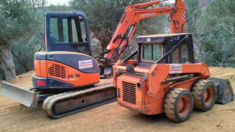 Ένας εκσκαφέας και ένα Bobcat εργάζονται δίπλα-δίπλα