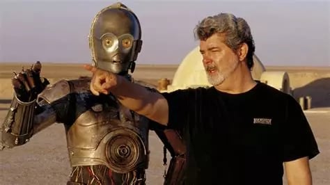 Georges Lucas à coté de C3PO dans le désert sur le tournage de la Guerre des Etoiles